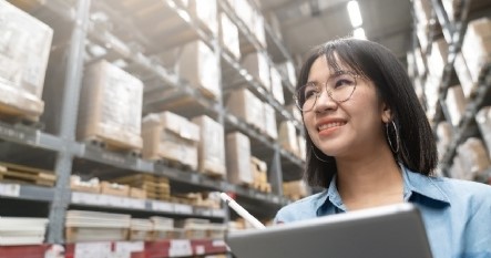 Woman taking warehouse inventory with tablet