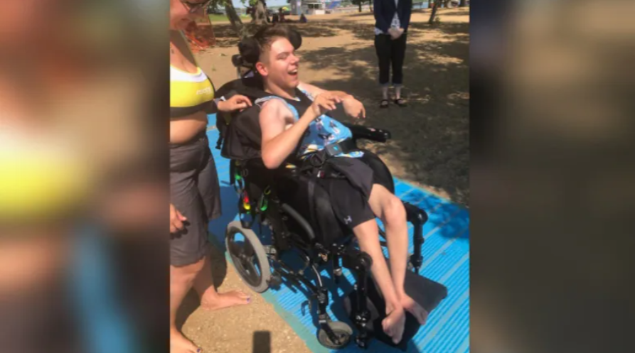 Bryce Vewchar and his mother Patricia Byziniak use the new access mat at Regina Beach. A group of local residents raised money to bring the mat and an accessible water wheelchair to the beach. (Submitted by Janey Davies)