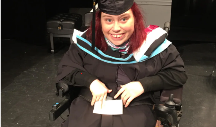 Picture of disabled young woman in wheelchair wearing graduation gown
