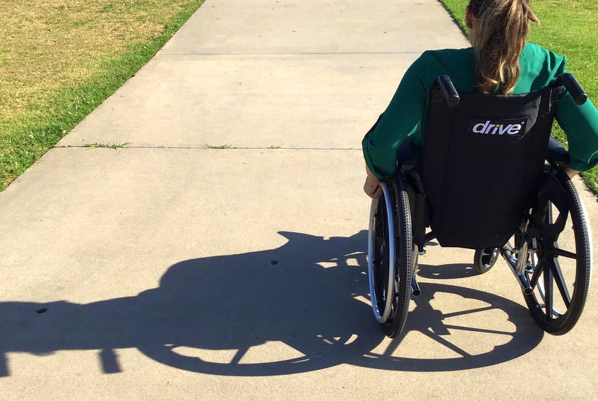 Woman in wheelchair looking far ahead of the road