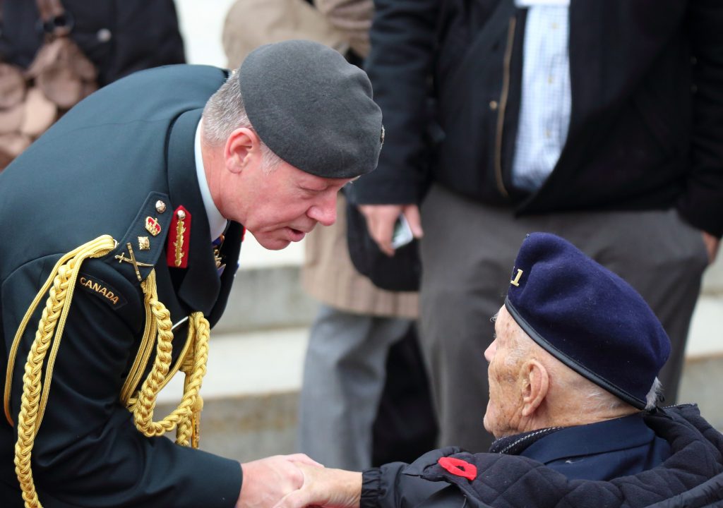 Chief of Defence Staff General Jonathan Vance talks with a veteran following the annual Remembrance Day ceremony at the National War Memorial.