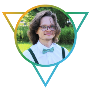 Photo: A staff photo of Alex Duerksen. He is an adult Caucasian man with long wavy brown hair, scraggly facial hair, round-rimmed glasses, and a white dress shirt and bow-tie.