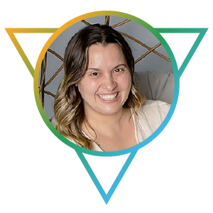 A staff photo of Adrienne Ottolino. She is a Caucasian woman with long wavy brown hair and white blouse. Her smile is bright and friendly.