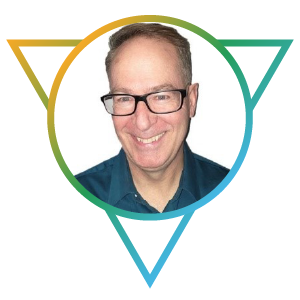 A staff photo of Brad Brohman. Brad is a mature Caucasian man with short grey hair, rectangular-rimmed glasses, and a blue button-down shirt. His smile is wide and welcoming.